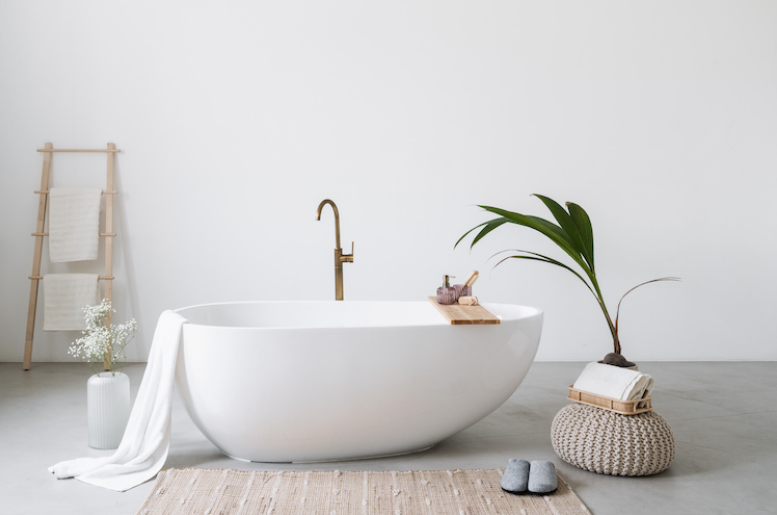 Imagen de un baño minimalista, con una bañera blanca sin bordes y una planta