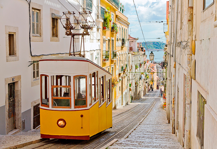 Tranvía amarillo subiendo por una de las calles inclinadas de Lisboa